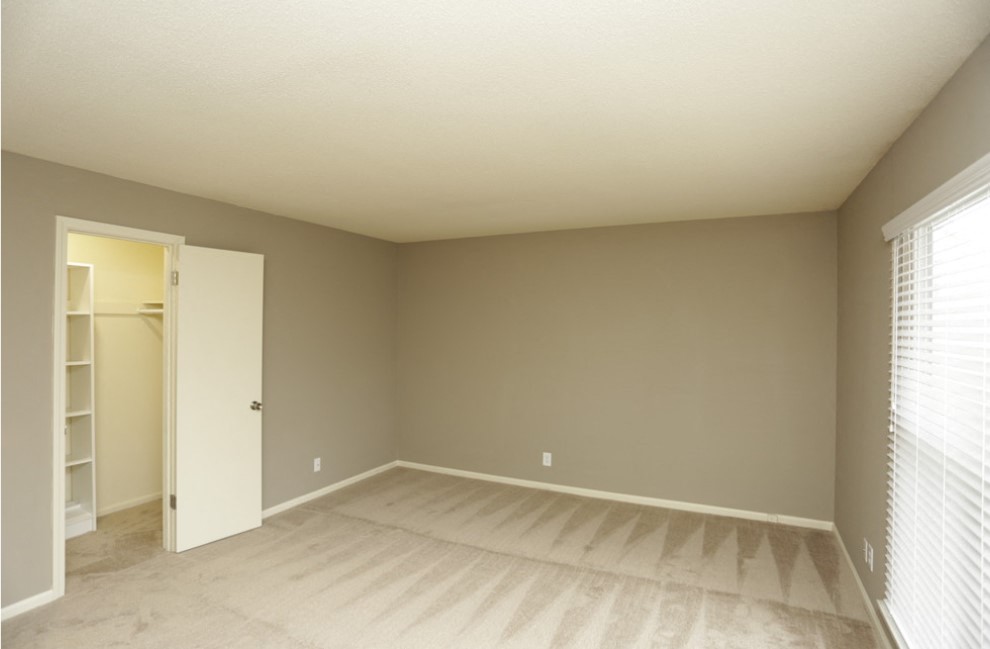 an empty living room with a door to a closet