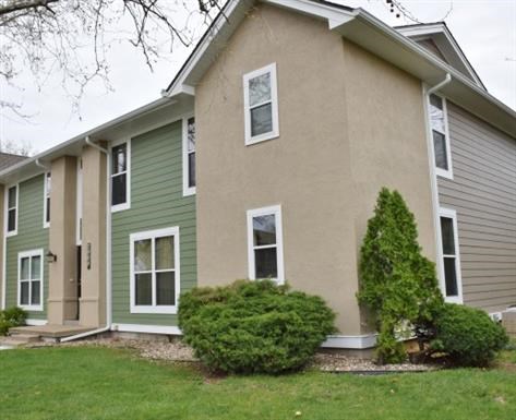 a brown and green house with a green yard
