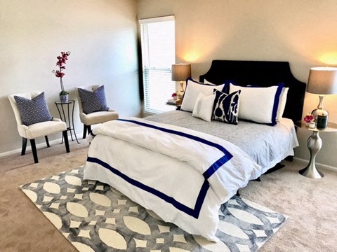 a bedroom with a bed and two chairs