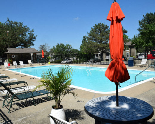 a swimming pool with an umbrella and chairs