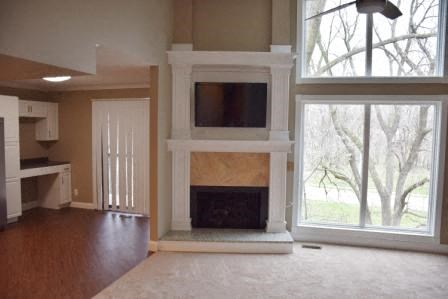 an empty living room with a fireplace and a tv