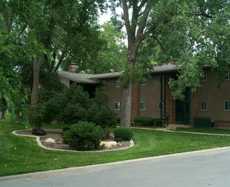 a house with a yard and trees in front of it