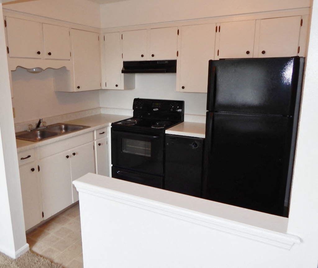 a kitchen with black appliances and white cabinets