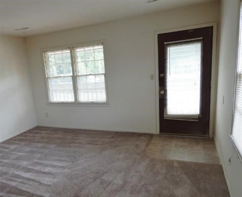 a empty living room with a door and windows