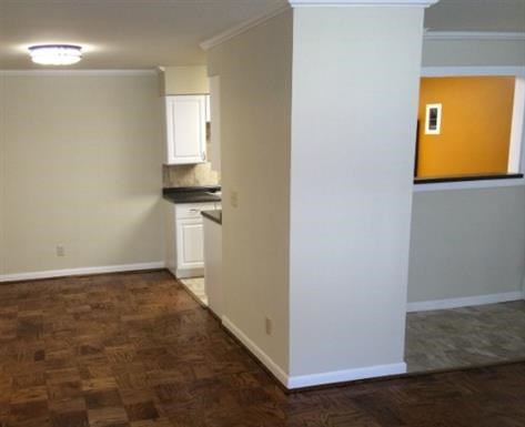 an empty living room with a kitchen in it