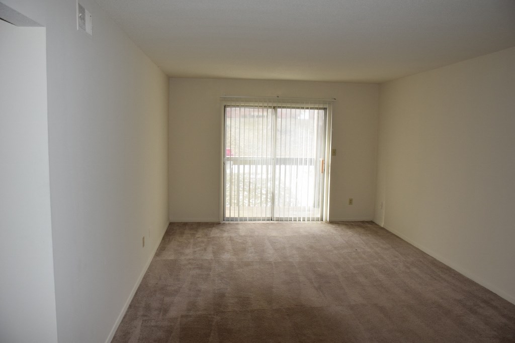an empty living room with a sliding glass door