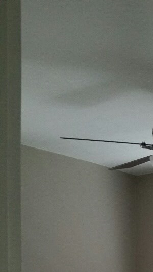 an empty room with a ceiling fan and a window