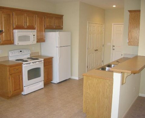 an empty kitchen with a stove and a refrigerator