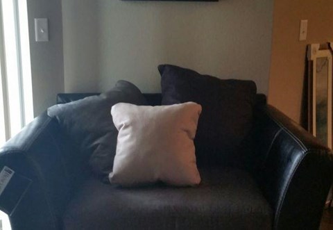 a black leather couch with white pillows on it