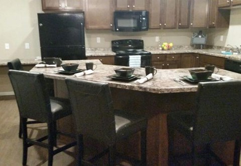 a kitchen with a large island with chairs