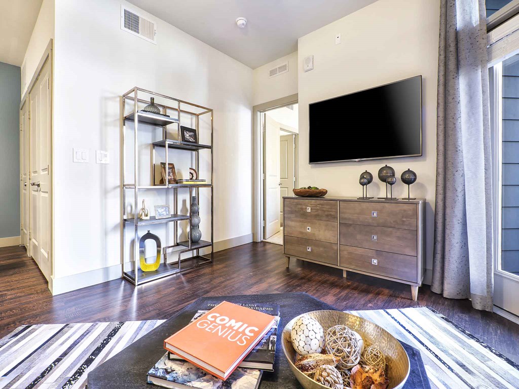 a living room with a tv and a table with books