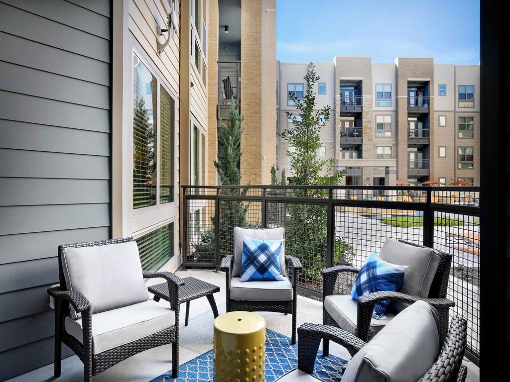 a balcony with patio furniture and a building in the background