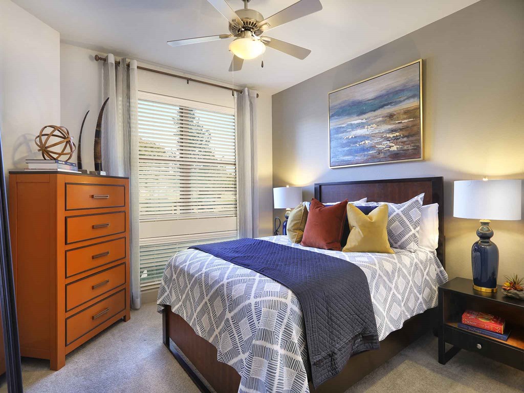 a bedroom with a bed and a ceiling fan