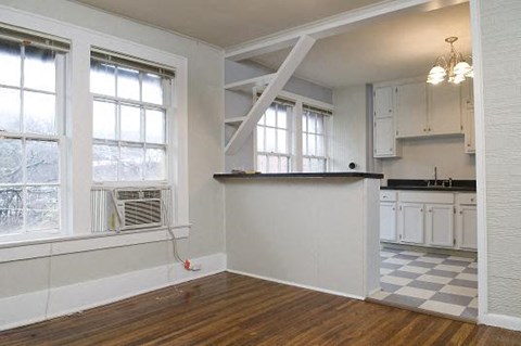 A kitchen with white cabinets and a black and white checkered floor.