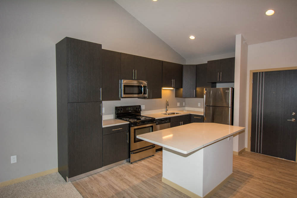 a kitchen with a white island and black cabinets