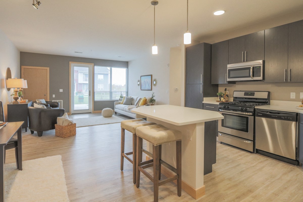 a kitchen and living room with an island and stools