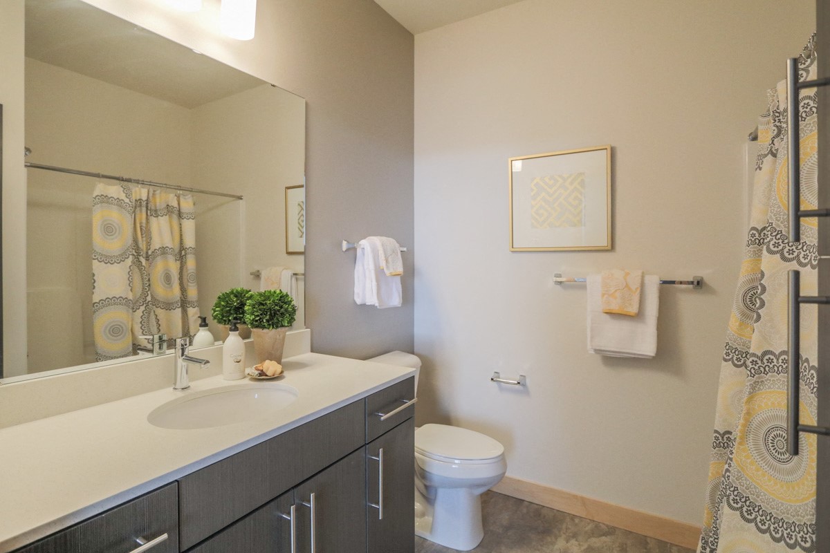 a bathroom with a large mirror and a toilet and sink