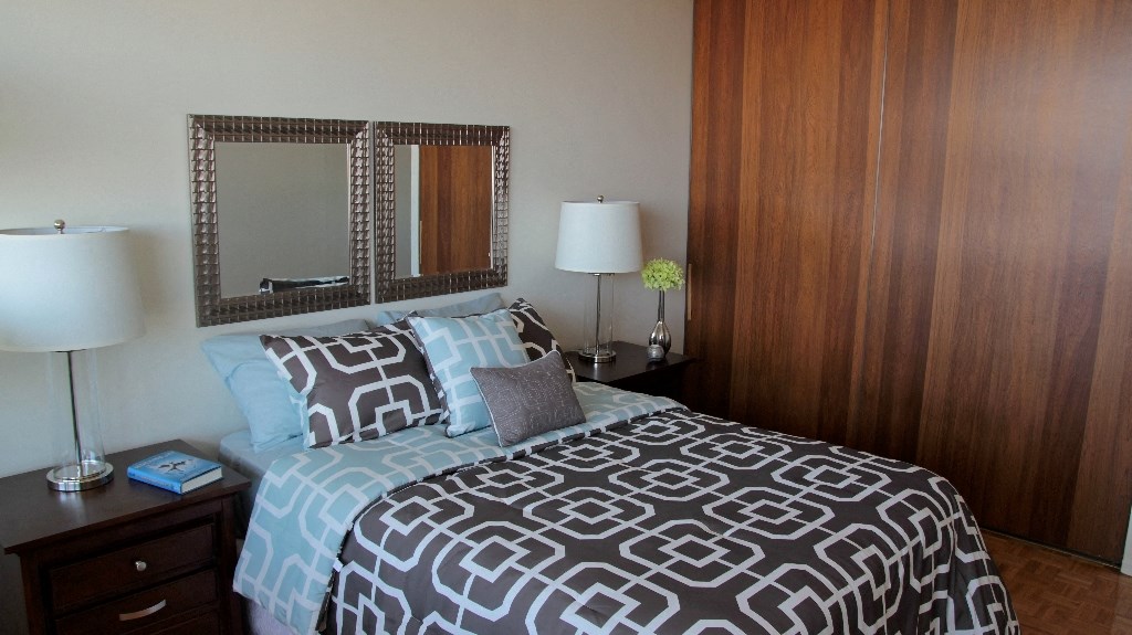 a bedroom with a bed and a dresser and a mirror