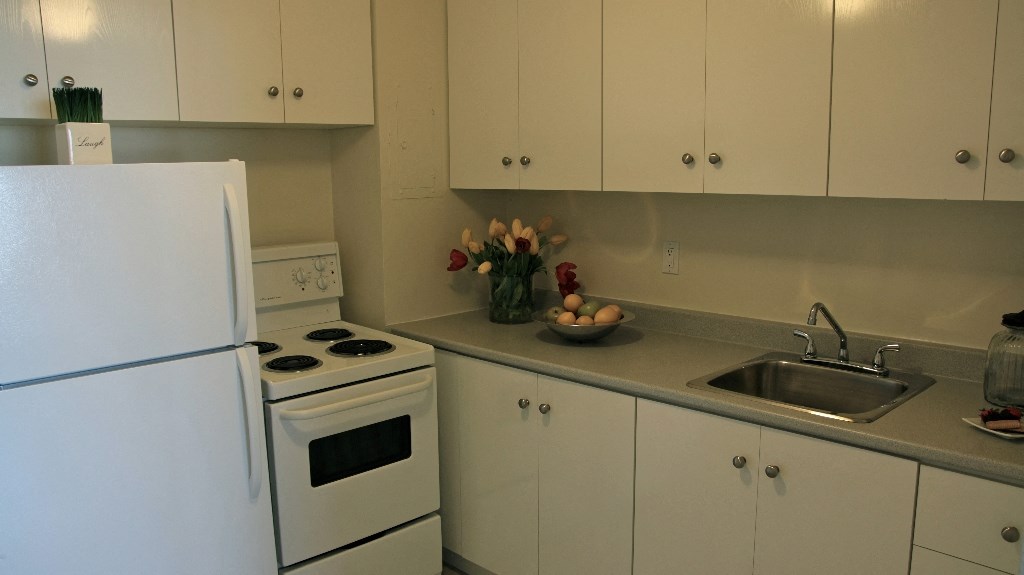 a small kitchen with white appliances and white cabinets