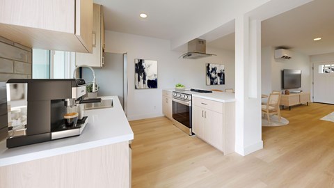 A modern kitchen with wooden floors and white walls.