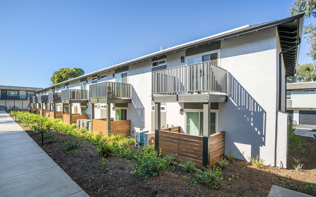 a row of apartments with balconies and a sidewalk