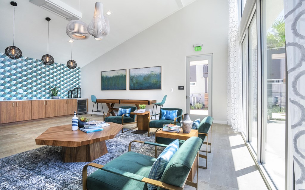 a living room with blue chairs and a wooden table