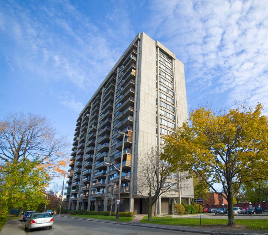 a tall building with balconies on the side of a street