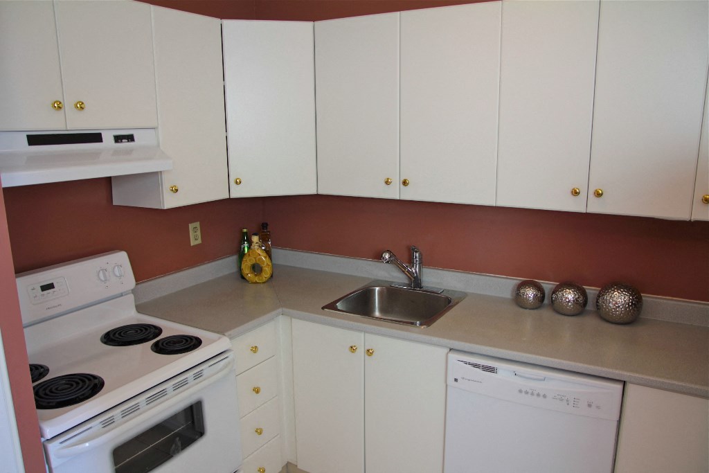 a kitchen with white appliances and white cabinets