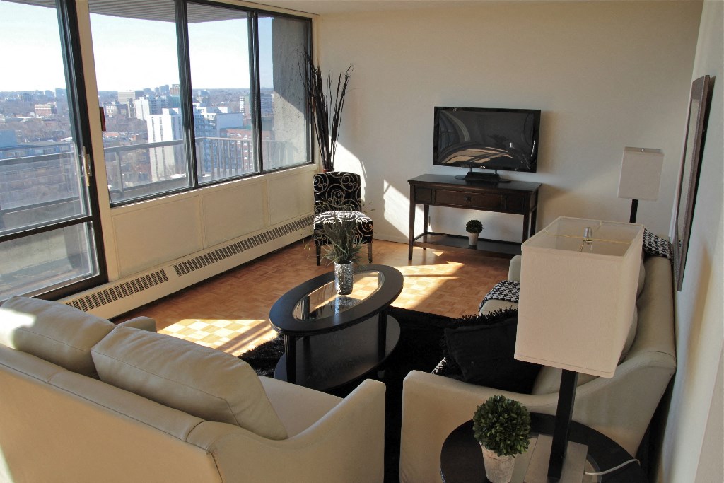 a living room with white couches and a table and a television