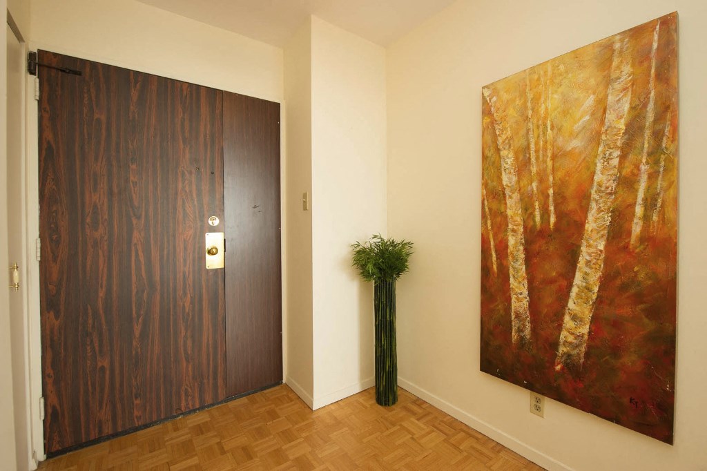 a room with a large painting on the wall and a wooden door