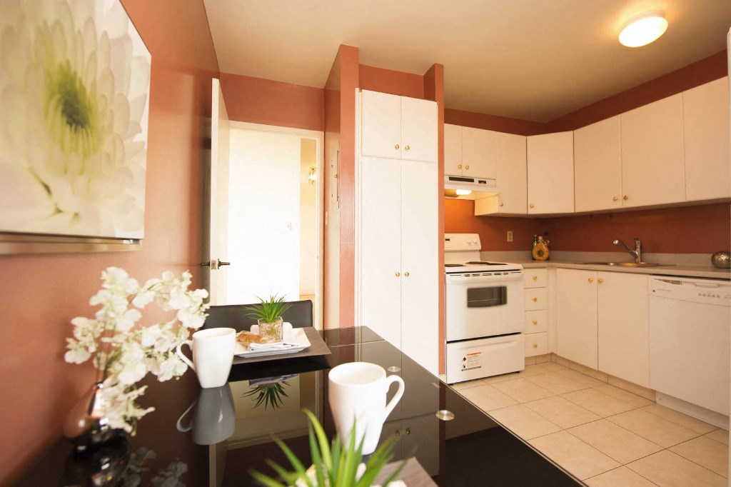 a kitchen with white cabinets and a black table