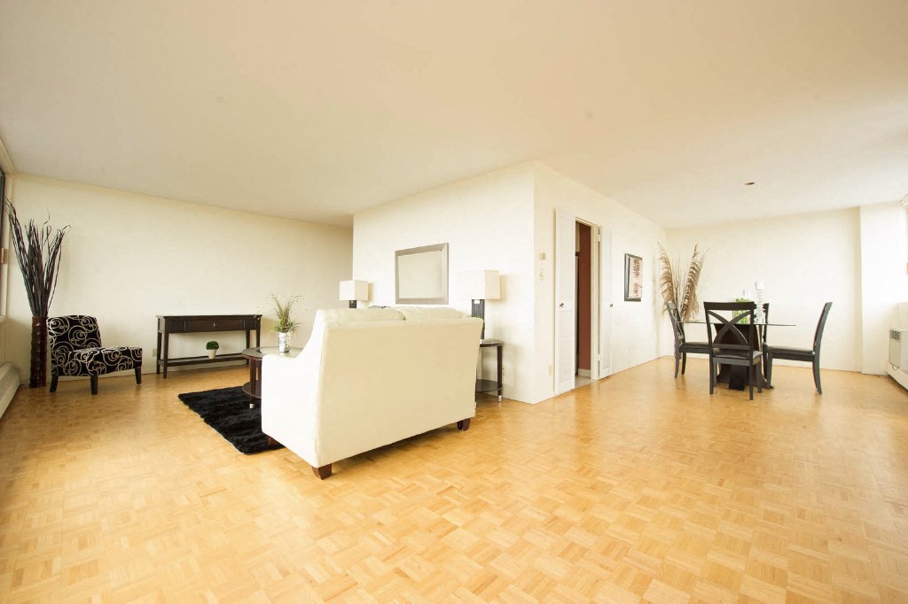 a living room with a white couch and a wooden floor