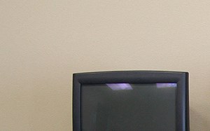 a computer desk with three monitors and keyboards on it