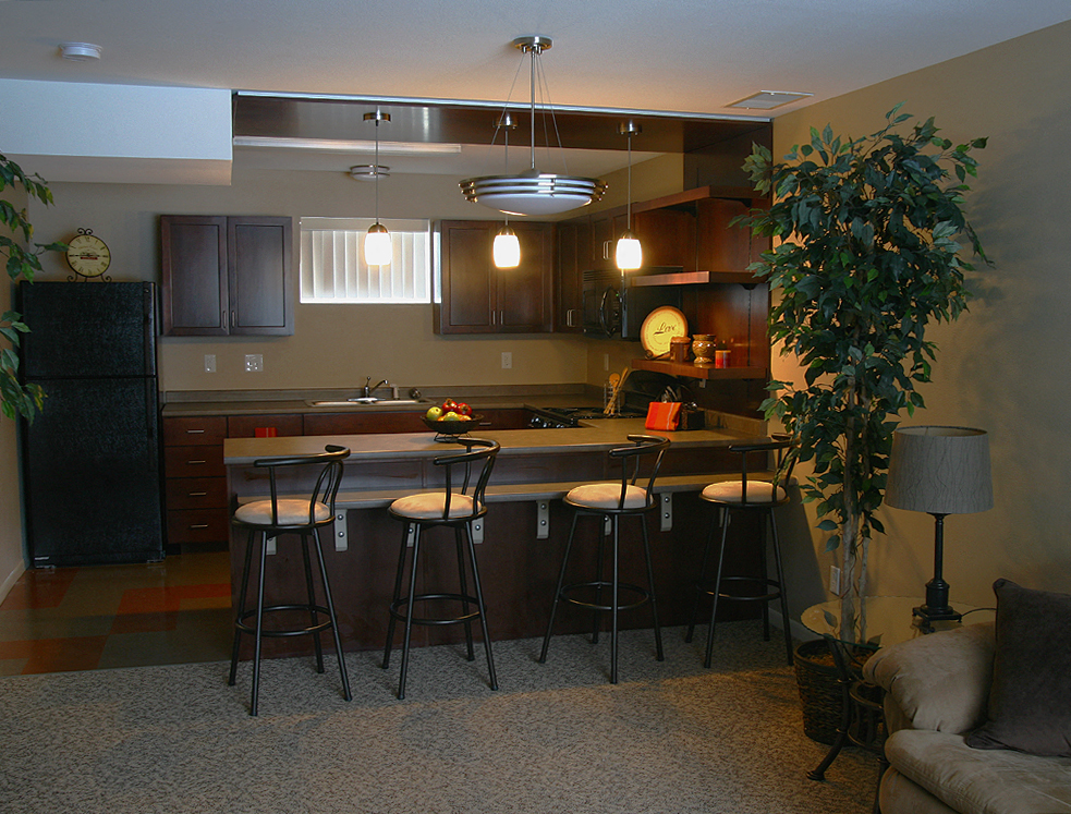 a kitchen with a bar and stools in a living room