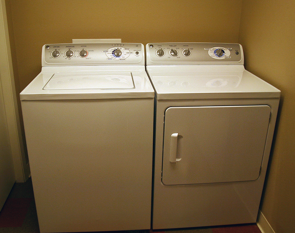 a pair of white washing machines are next to each other