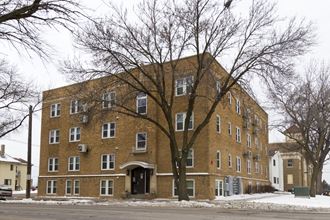 The exterior of Murray Apartments as a four story brick building surrounded by trees.