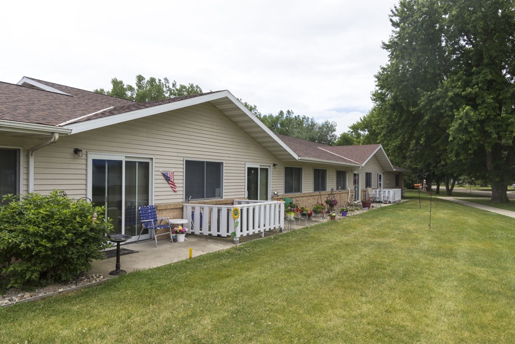 a row of houses with a porch and a lawn