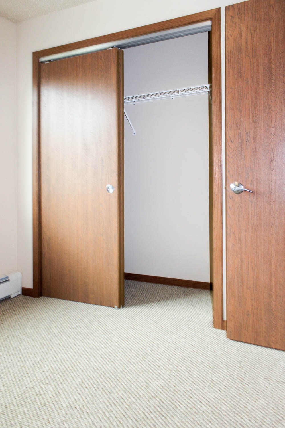 a closet with an open door and a carpeted floor