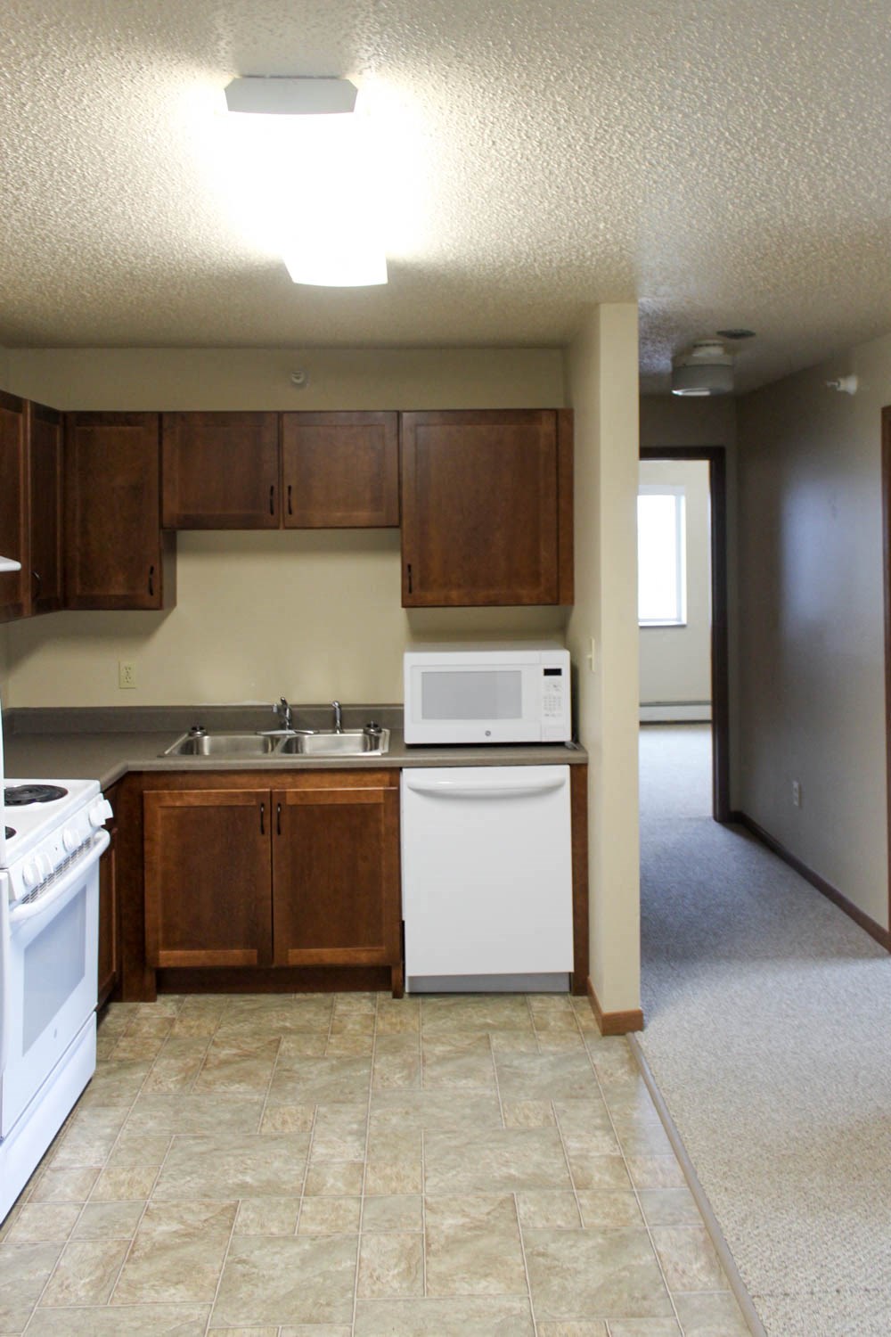 a kitchen with white appliances and wooden cabinets