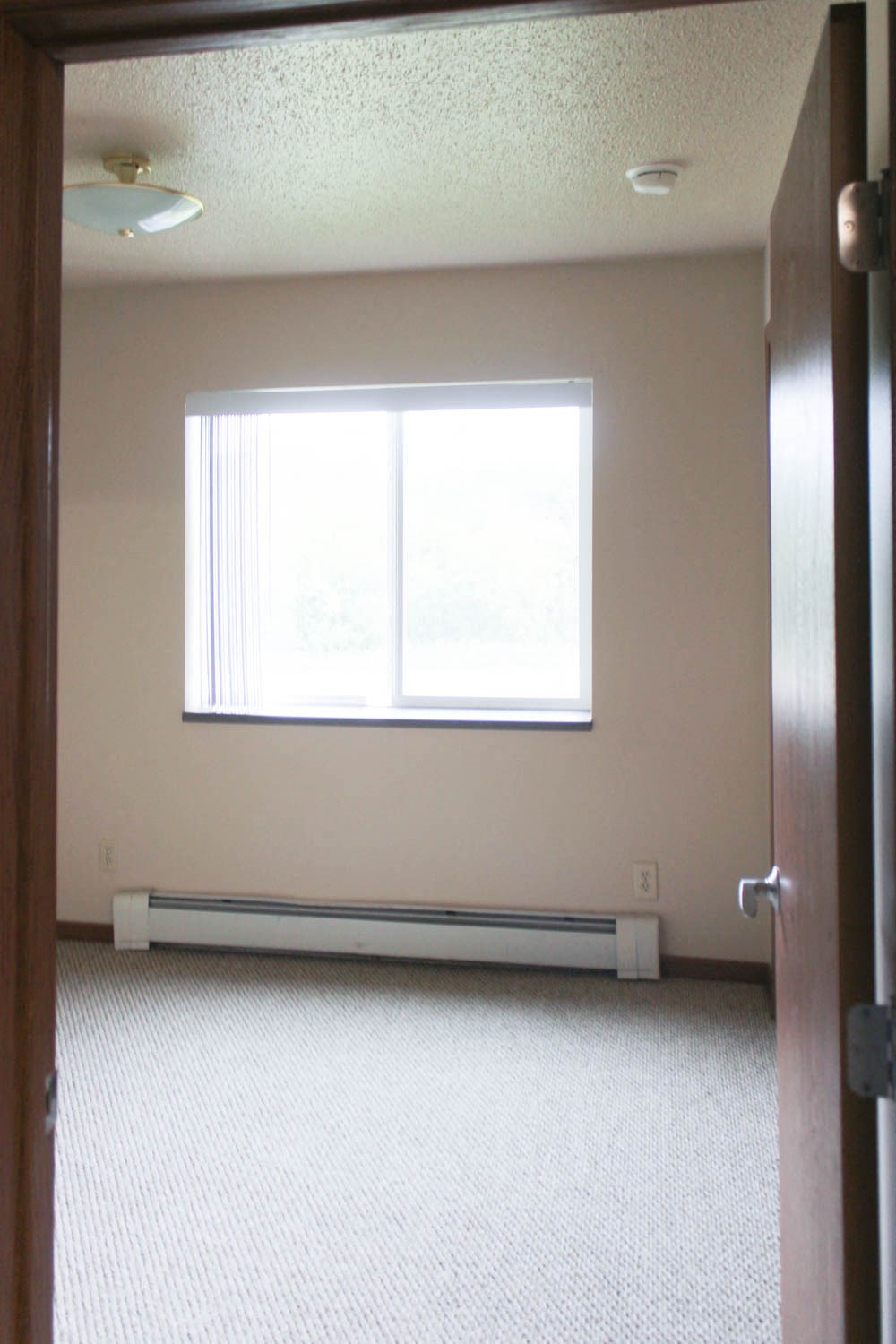 an empty room with a window and a door