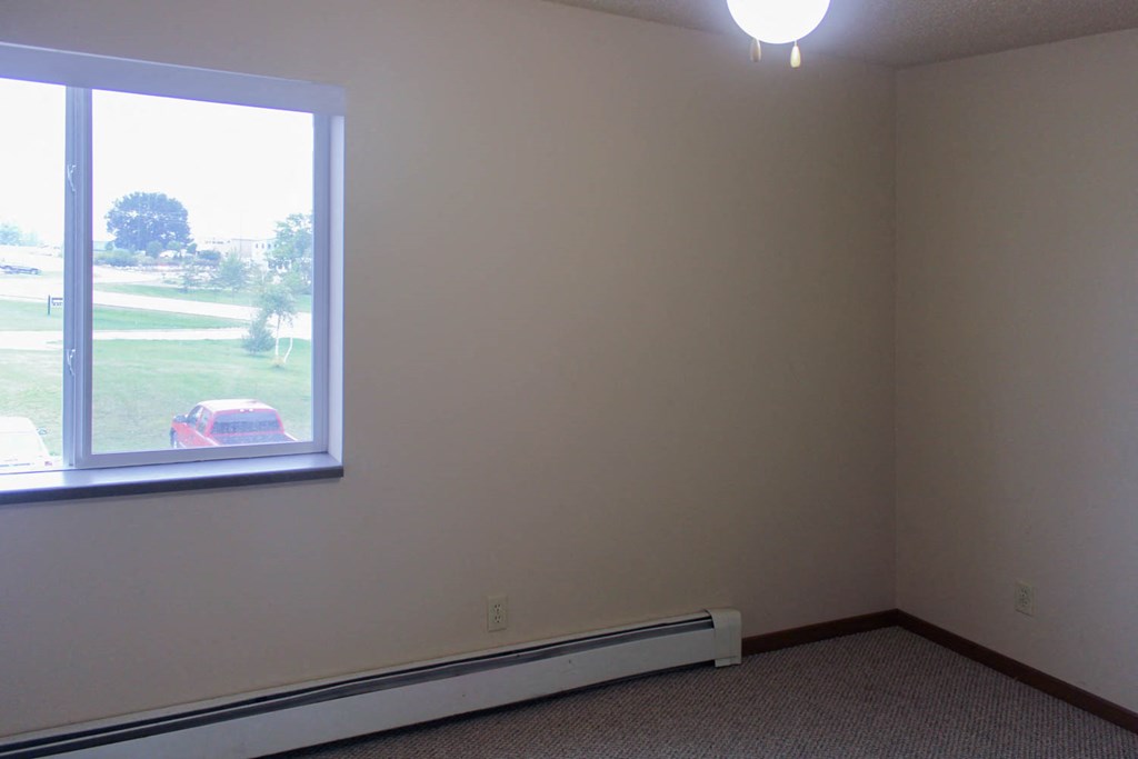 a room with a large window and a carpet