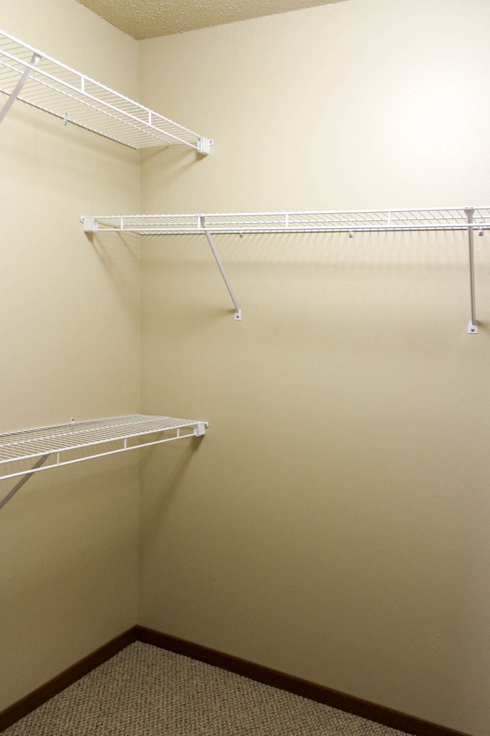 a walk in closet with empty shelves