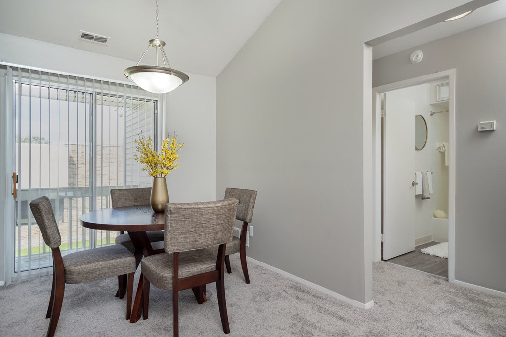 a dining room with a table and chairs and a large window