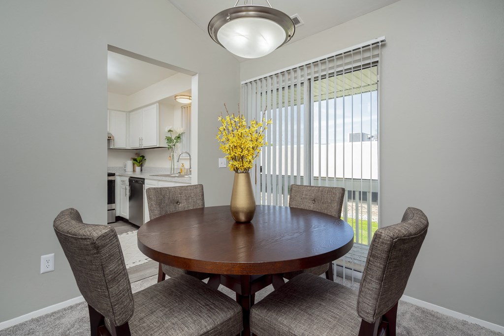 a dining room with a table and chairs and a large window