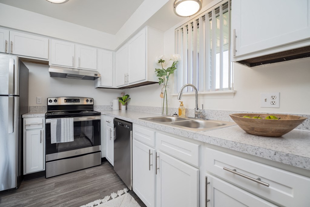 a white kitchen with stainless steel appliances and white cabinets