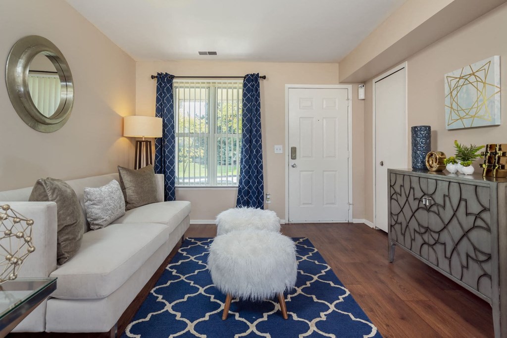 a living room with a white couch and a stool