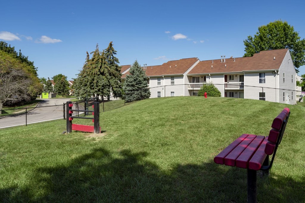a park bench sitting on top of a lush green field