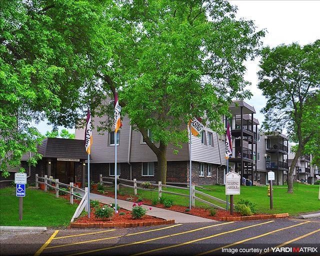 a building with flags and trees in front of it
