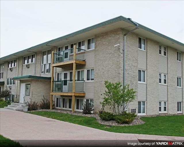 an apartment building with a sidewalk in front of it
