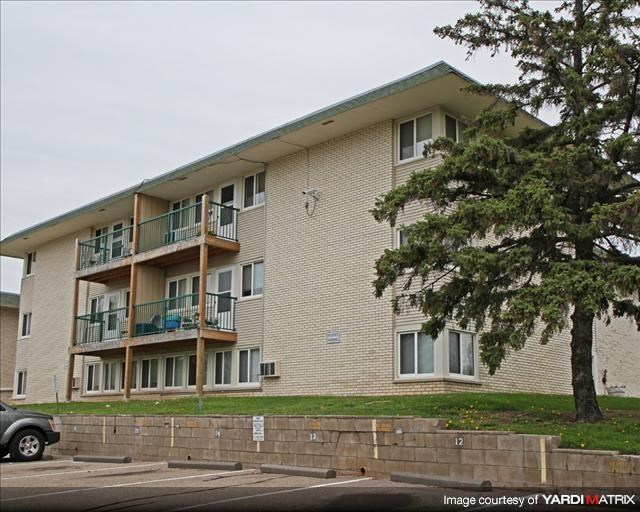 a large apartment building with a tree in front of it